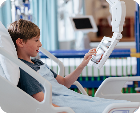 Hospital patient in bed using bedside monitor