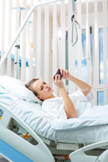 Girl on smartphone in hospital bed